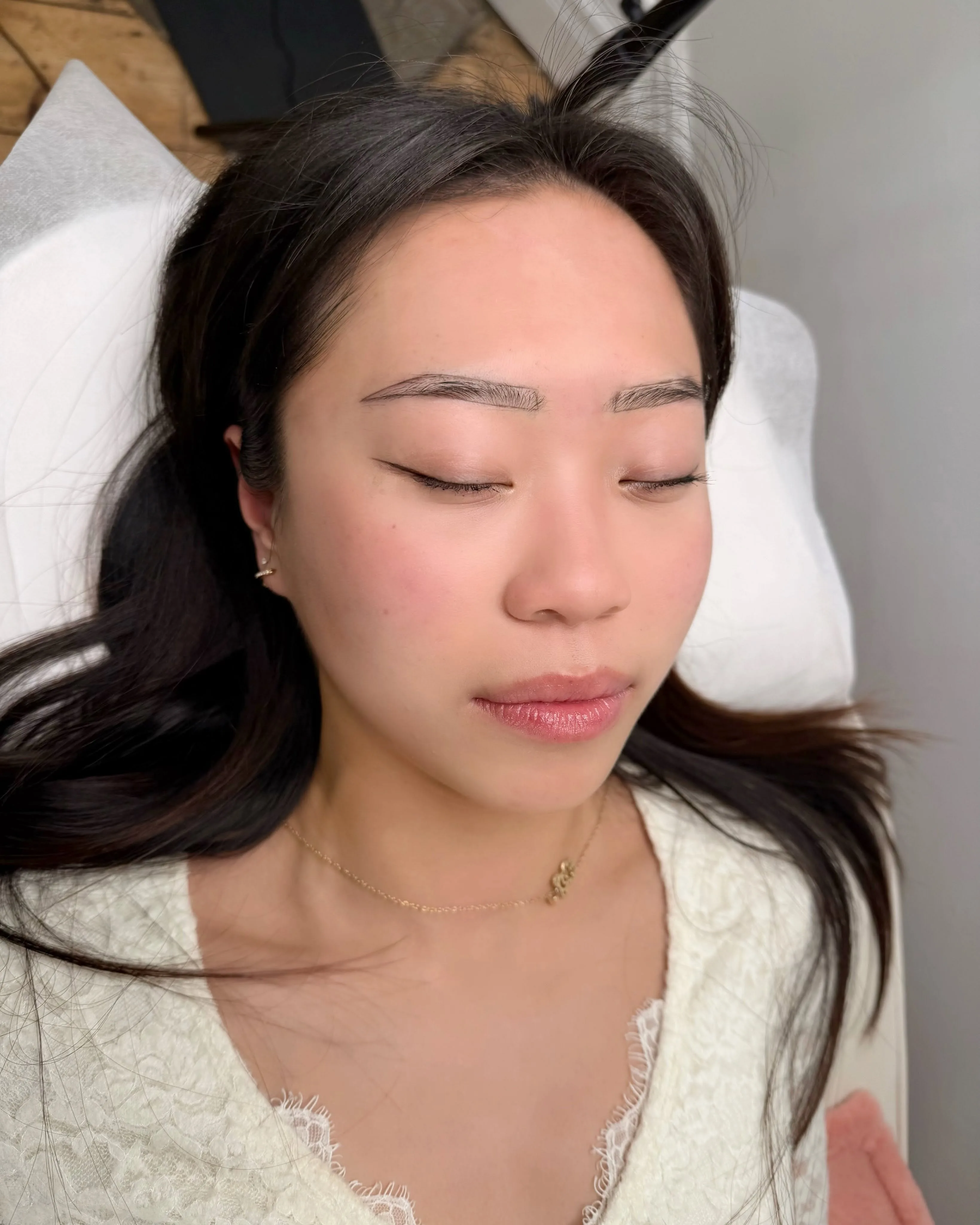 Client reclining with freshly-healed hairstroke brows — Brows By Liz
